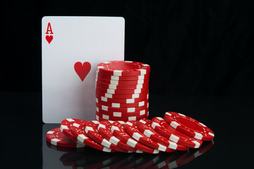 on a black background with reflection, close-up of the highest card and red chips,for playing poker, with space for inscription