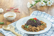 © pichayut - Stir fried basil with minced pork and berry rice in a plate on a wooden table.