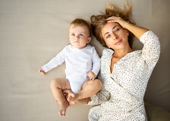 happy mother with her son lying on the bed, top view, mother's day