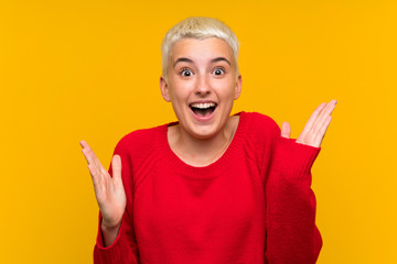 Teenager girl with white short hair over yellow wall with surprise facial expression