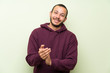 © luismolinero - Colombian man with sweatshirt over green wall applauding