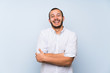 © luismolinero - Colombian man over isolated blue wall smiling