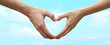 © chinnarach - close up couple human hand gesture heart shape on blur blue sky background fro world environment day concept