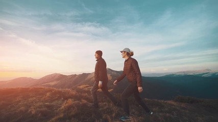 Wall Mural - the happy couple walking in the mountain on the sunny background. slow motion