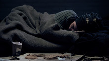 Homeless Person Covered By Blanket Sleeping On City Street, Poverty Concept
