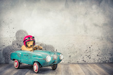 Retro Teddy Bear Toy Racer In Old Helmet Hat With Aviator Goggles Driving Antique Rusty Turquoise Pedal Car From 60s Front Concrete Wall Background With Shadow Concept. Vintage Style Filtered Photo