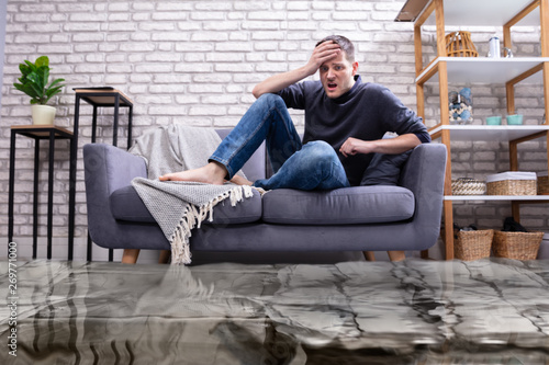Cuadros en Lienzo Upset Man In The Room Flooded With Water