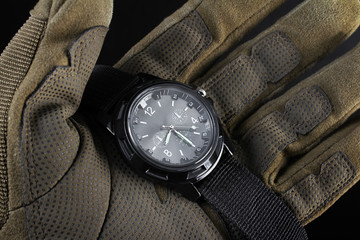 Wall Mural - Soldier arm holding black tactical watch close up.