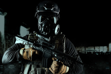 Wall Mural - Warrior soldier in gas mask and rifle on black background.