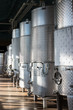 Closeup of Row of Insulated Cold Storage Tanks for Beer or Wine with Overhead Pipes