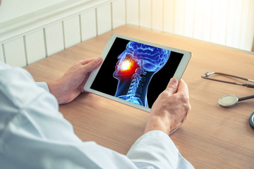 Wall Mural - Doctor or dentist holding a digital tablet with x-ray of skull with pain on the teeth