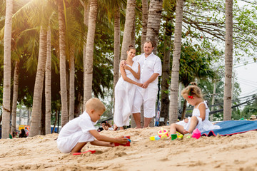 Wall Mural - Happy young family on the sunset at the beach.