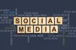 © vallerato - Social Media concept. Social Media words, written on wooden blocks against the background of different inscriptions Social Media. Dark background. Social Media background. Communication.