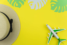 Flat Lay Traveler Accessories On Yellow Background With Straw Hat, Palm Leaf, Airplane. Top View Travel And Planning Summer Vacation Concept. 