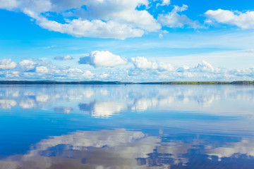  Summer lake landscape with fine reflections and dramatic sky. Sotkamo, Finland.
