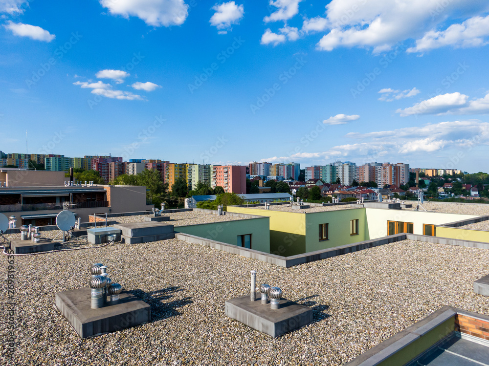 Aerial view of house flat roof on residental building. Modern architecture exterior. Air conditioning systems and ventilation structure. Residental building in background, sunny day - obrazy, fototapety, plakaty 
