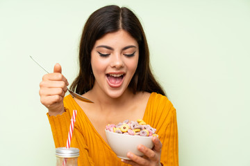 Happy Teenager girl having breakfast with bowl of cereals