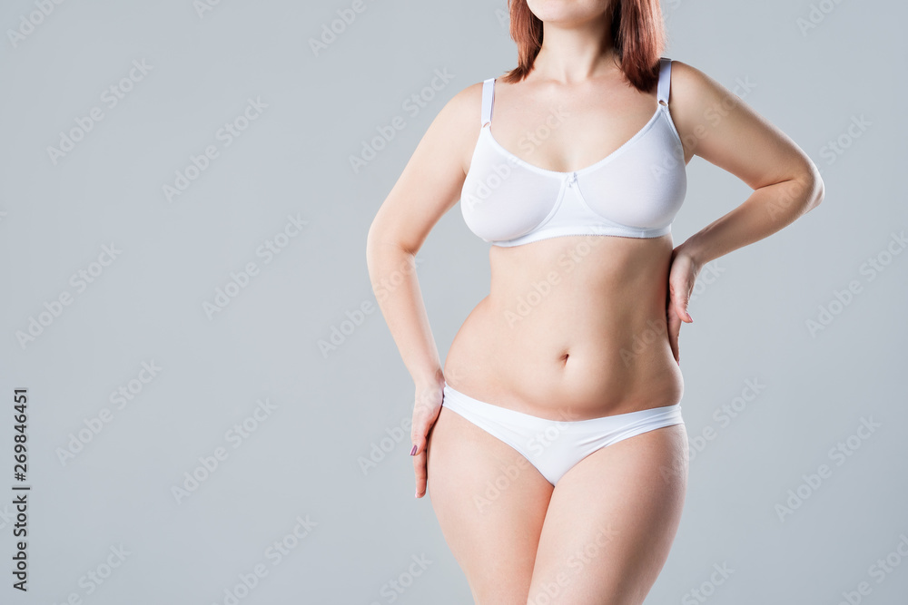 Woman with fat flabby belly, overweight female body on gray background - obrazy, fototapety, plakaty 