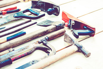 Set of vintage hand construction tools on a wooden background .