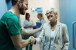 © Drazen - Happy senior woman shaking hands with a surgeon at hospital hallway.