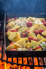 Wall Mural - Baked potatoes na grill with garlic and rosemary on bonfire