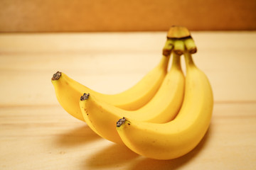 Three fresh and ripe yellow banana on a wooden base