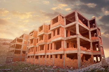 Wall Mural - Building construction site from concrete and brick against sunset.