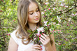 © Iveta - Young caucasian woman stay in garden and looking at flowers bouquet