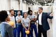 Leinwandbild Motiv Company manager giving presentation to group of workers in a factory.