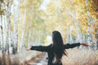 © Daniil - Dreamy beautiful girl with long natural black hair flies on bokeh background of autumn yellow leaves. Autumn euphoria in faded tones. Inspired emotional girl enjoys nature in fall forest. Back view.