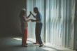 © Creativa Images - Happy elderly couple dances near the window