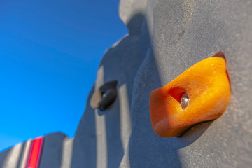 Close up of a climbing wall at a playground with clear blue sky background