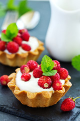 Wall Mural - Wild strawberry tartlets with cream filling. delicious summer fruit mini tarts