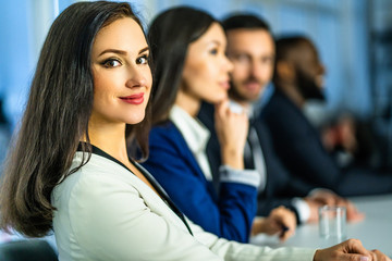 Wall Mural - The beautiful businesswoman sitting at the table near colleagues