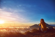 © astrosystem - Woman enjoying nice landscape and sunrise from a top of mountain Batur, Bali, Indonesia.