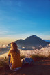 © astrosystem - Woman enjoying nice landscape and sunrise from a top of mountain Batur, Bali, Indonesia.