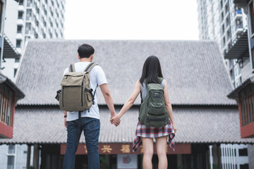 Traveler Asian backpacker couple feeling happy traveling in Beijing, China, cheerful young teenager couple walking at Chinatown. Lifestyle backpack tourist travel holiday in city concept.