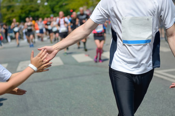 Wall Mural - Marathon running race,runners support on road race, child's hand giving highfive, kid supporting athletes who run, sport concept