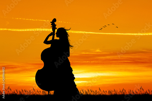 Obrazy wiolonczela  kobieta-gra-na-wiolonczeli-o-zachodzie-slonca