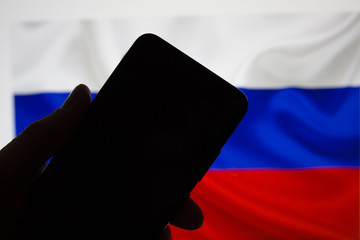 Smartphone with a blank black screen for the inscription on the background of the Russian flag