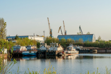 Old pier, moored old ships and yachts, seagulls fly from the coast. Spring, sunny weather.