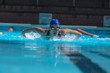 © Wavebreak Media - Young female swimmer with swim goggle swimming at swimming pool