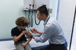 © Wavebreak Media - Young asian male doctor injecting syringe to caucasian boy patient in clinic