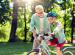 © Syda Productions - family, generation, safety and people concept - happy grandfather teaching boy how to ride bicycle at summer park
