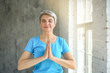 © Pixel-Shot - Sporty mature woman practicing yoga at home