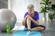 © Pixel-Shot - Sporty mature woman with injured knee after training at home