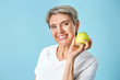 © Pixel-Shot - Mature woman with apple on color background