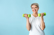 © Pixel-Shot - Sporty mature woman with dumbbells on color background