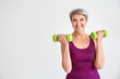 © Pixel-Shot - Sporty mature woman with dumbbells on light background