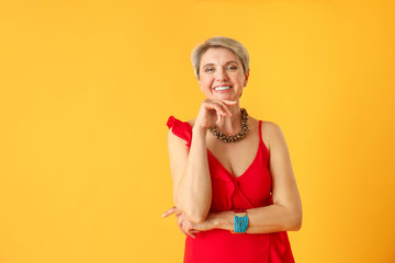 Fashionable mature woman on color background